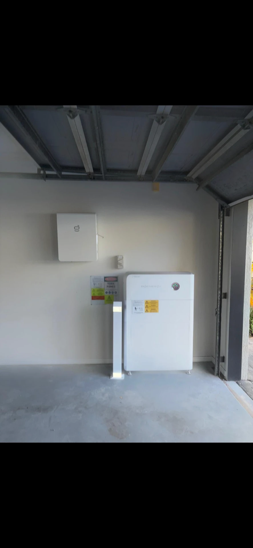 Compact battery and inverter installation on a garage wall